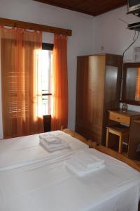 a bedroom with a large white bed and a window at Smile 2 in Kassiopi