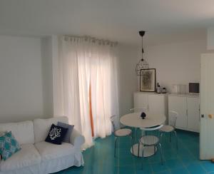 un soggiorno con divano bianco e tavolo di Apulia Beach a Leporano