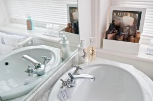 a white bathroom with a sink and a mirror at The Laindons in Hastings