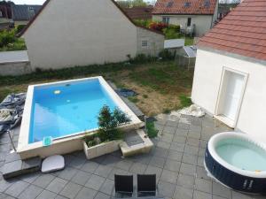 a swimming pool on a patio with a bath tub at 4 Chambres meublées et un seul studio avec petite cuisine in Til-Châtel