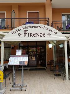 a store with a white canopy in front of a building at Hotel Firenze in Malcesine