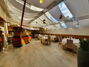 a restaurant with tables and a boat on the ceiling at Restaurant and rooms Kotlar in Kobarid