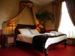 a bedroom with a large bed with a canopy at Hotel Pegasus in Apeldoorn