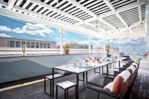 d'une terrasse sur le toit avec des tables et des chaises. dans l'établissement La Terrazza Sul Porto, à Cagliari