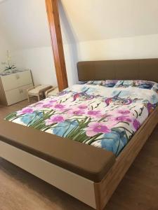 a bedroom with a bed with flowers on it at Tisza-Tavi Apartmanok in Tiszafüred