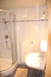 a bathroom with a sink and a shower and a toilet at Gasthof Walde in Rifiano