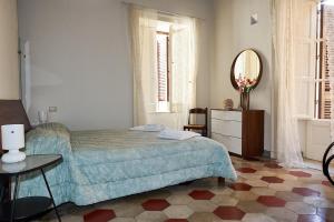 1 dormitorio con cama, espejo y mesa en Casa Conte, en Sorrento