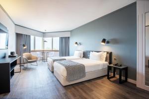 Una habitación de hotel con una cama grande y una mesa. en HF Fenix Porto, en Oporto