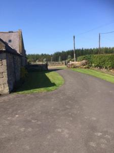 an empty road next to a building and a bridge at East Cawledge Farm in Alnwick