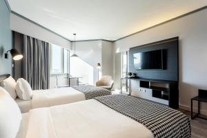 a hotel room with two beds and a flat screen tv at HF Fénix Porto in Porto