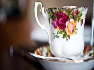 a coffee cup with flowers on it sitting on a saucer at Bamflatt Farm Bed & Breakfast in Strathaven +23 photos