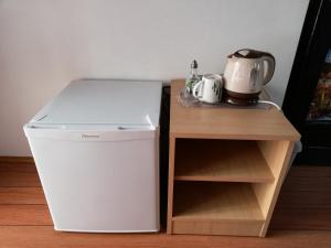 a small refrigerator next to a table with a tea kettle at Rooms Hazler in Slunj