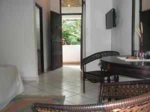 Habitación con mesa, sillas y puerta en Papillon Garden Bar Villas en Bamburi