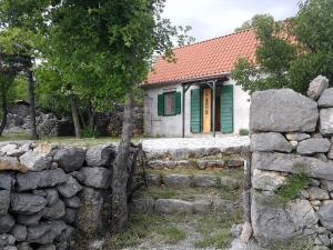 a stone fence in front of a small house at House Kaja in Jablanac