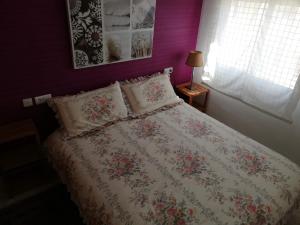 a bedroom with a bed with a floral bedspread and a window at Mediterránea Solo Familias Serviplaya in Playa de Xeraco +94 photos