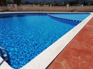 een groot zwembad met blauw water bij Mediterránea Solo Familias Serviplaya in Playa de Xeraco