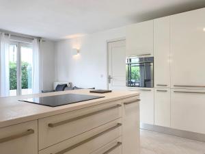 a kitchen with white cabinets and a counter top at Résidence Panoramer in Cannes