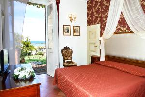a bedroom with a red bed and a window at Hotel Locanda delle Dune in Bellaria-Igea Marina