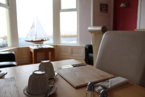 a wooden table with two mugs on top of it at The Ashley in Morecambe