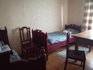 Cette chambre comprend deux lits, une table et des chaises. dans l'établissement Lauku viesu māja Bajāri, à Rucava