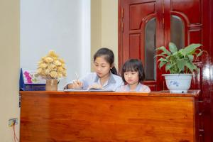 a woman and a child sitting at a desk at Mai Place Homestay in Ninh Binh