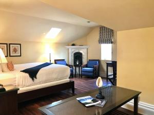 a bedroom with a bed and a table and a fireplace at West Cliff Inn, A Four Sisters Inn in Santa Cruz
