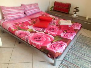 ナポリにあるMiseria e Nobiltà Apartment CHECK-IN FROM 12 00 TO 15 00のピンクのバラが飾られたベッド1台