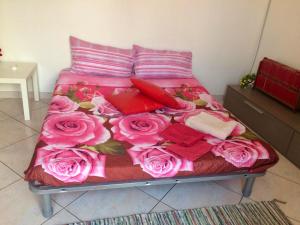 ナポリにあるMiseria e Nobiltà Apartment CHECK-IN FROM 12 00 TO 15 00のピンクのバラがたくさんのベッド