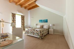 Il Sonno dei Giusti Apartment by DomuSicily في باليرمو: غرفة نوم بيضاء بها سرير ونافذة