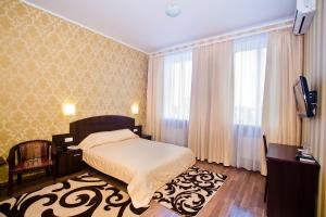 a bedroom with a bed and a tv and curtains at City Club in Kharkiv