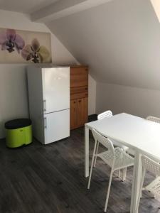 eine Küche mit einem weißen Tisch und einem weißen Kühlschrank in der Unterkunft Oftersheim am Wald Kick Apartment in Oftersheim