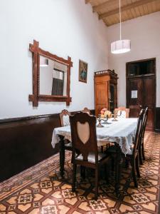 comedor con mesa con sillas y espejo en Samanai Wasi Hostel, en Lima