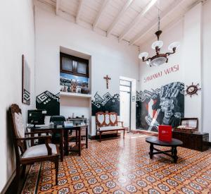 Pokój ze stołami i krzesłami oraz ścianą z malowidłem ściennym w obiekcie Samanai Wasi Hostel w mieście Lima