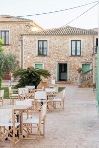 a patio with tables and chairs in front of a building at Curolla Petit Hotel in Maria de la Salut