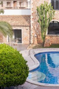 a swimming pool in front of a building at Curolla Petit Hotel in Maria de la Salut