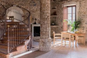 salon ze spiralnymi schodami i stołem w obiekcie Curolla Petit Hotel w mieście Maria de la Salut