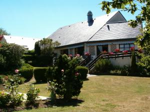 a house with a garden with flowers in the yard at Campanile Saumur in Saumur