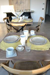 uma mesa de madeira com pratos e pratos em B&B Cloud em Santa Maria Capua Vetere