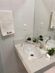 a bathroom with a sink and a mirror at POUSADA LUNARA in Jequié