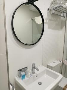 a bathroom with a white sink and a mirror at Apartamentos Las Palmeras in Palma del Río