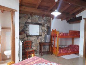 a bedroom with two bunk beds and a stone wall at B&b Gennargentu in Fonni