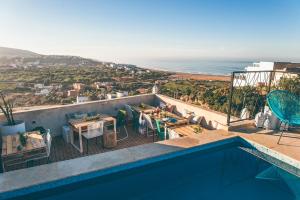 a swimming pool with a view of the ocean at The Yogi Surfer in Taghazout