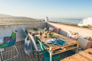 a table and chairs on a balcony with the ocean at The Yogi Surfer in Taghazout