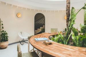 an office with a wooden table and some plants at The Yogi Surfer in Taghazout