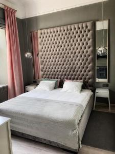 a bedroom with a large bed with a large headboard at Fountain Appartement in Lviv