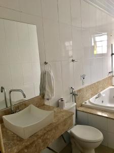 a bathroom with a sink and a toilet and a tub at Hotel Fazenda Mangalarga in Paty do Alferes