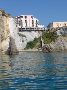 Un edificio su una scogliera vicino a un corpo d'acqua di Hotel Bellavista a Ponza