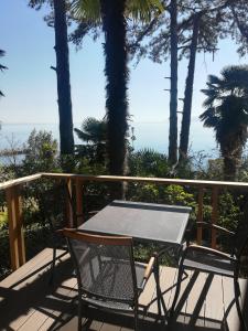 uma mesa e cadeiras numa varanda com o oceano em Studio apartman Arni em Rijeka