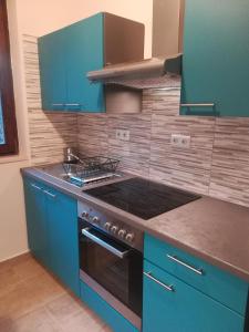 uma cozinha com armários azuis e um forno com placa de fogão em Studio apartman Arni em Rijeka