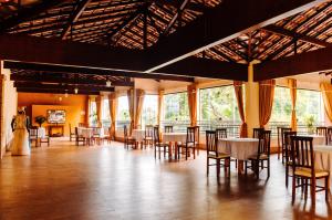 a banquet hall with tables and chairs and windows at Hotel Fazenda Mangalarga in Paty do Alferes